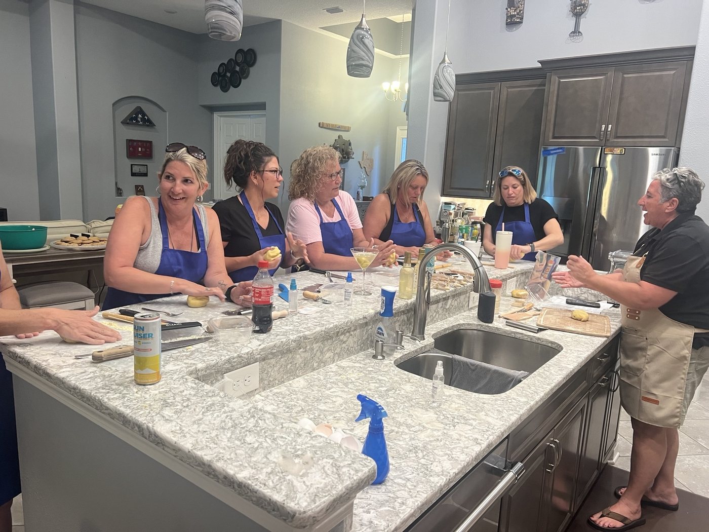 Guests making pasta together in a home kitchen